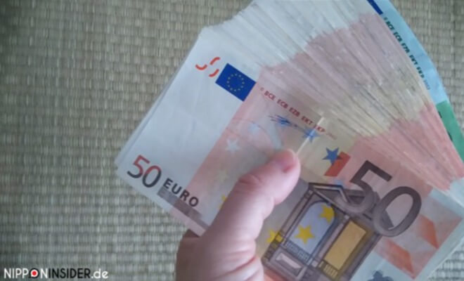 Japanische Männer und Geld: eine Hand überreicht einen Packen Geldscheine | Nipponinsider Japanwelt