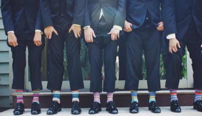 Thema Klischees und Stereotypen: Männer mit dunklen Anzügen in einer Reihe. Heben ihre Hosen hoch und es sind geringelte Socken in unterschiedlichen Farben zu sehen. | Nipponinsider Japanblog