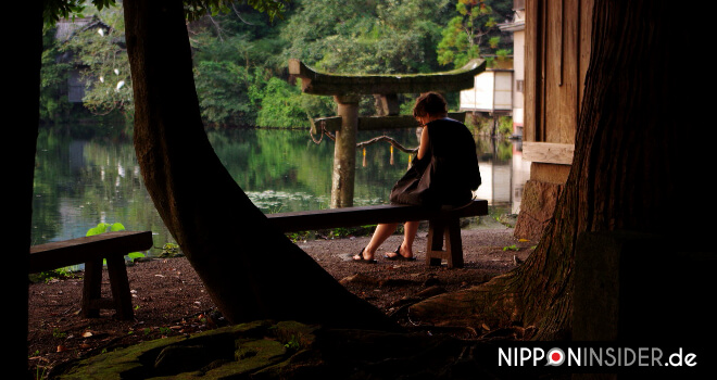 Wie oft reist ihr nach Japan? FAQ: Vor einem See sitzende Frau in Japan | Nipponinsider